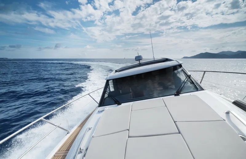 Slide: The Image of 2025 Skamander Monaco Coupe yacht cruising on open sea under a partly cloudy sky. - 24