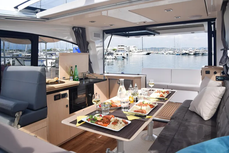 Slide: The Image of Luxurious interior of 2025 Skamander Monaco Coupe yacht with dining setup and marina view. - 27
