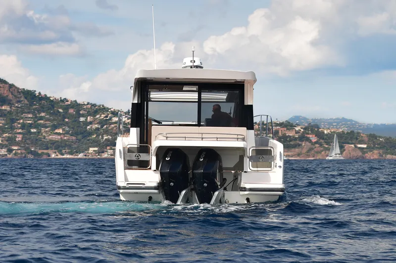 Slide: The Image of 2025 Skamander Monaco Coupe yacht cruising on open water with scenic coastal backdrop. - 30