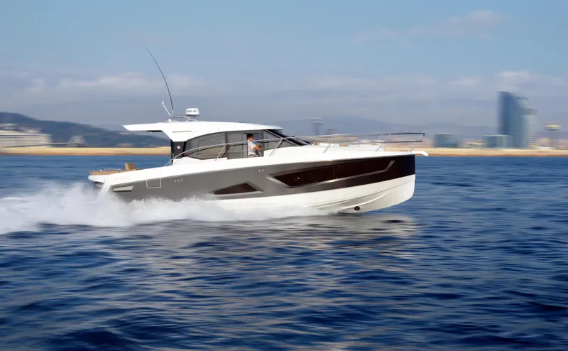 Slide: The Image of 2025 Skamander Monaco Coupe cruising on open water, cityscape in background. - 32