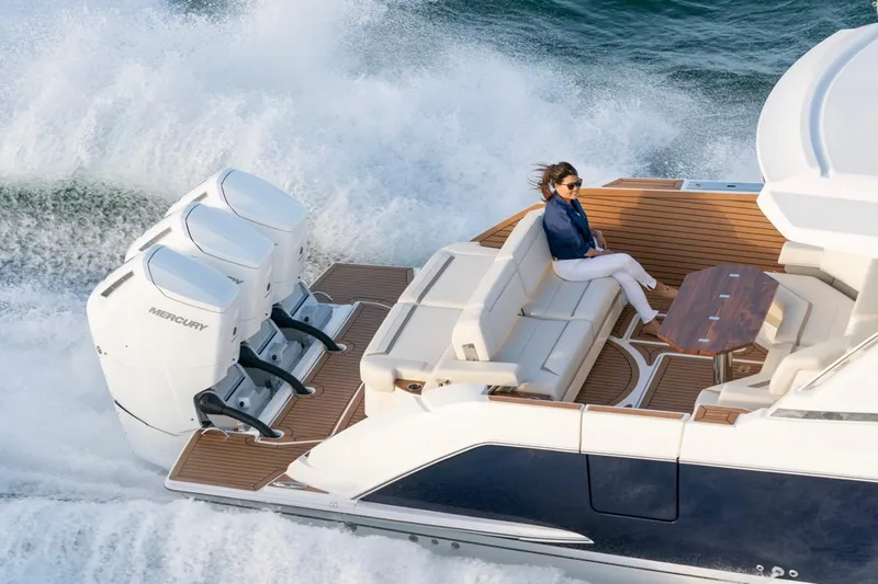 Slide: The Image of 2025 Tiara Yachts 48 LS cruising with powerful Mercury engines, elegant seating, and teak decking. - 4
