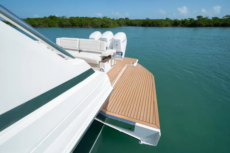 Slide: The Image of 2025 Tiara Yachts 48 LS with spacious deck and triple engines on calm water. - 6