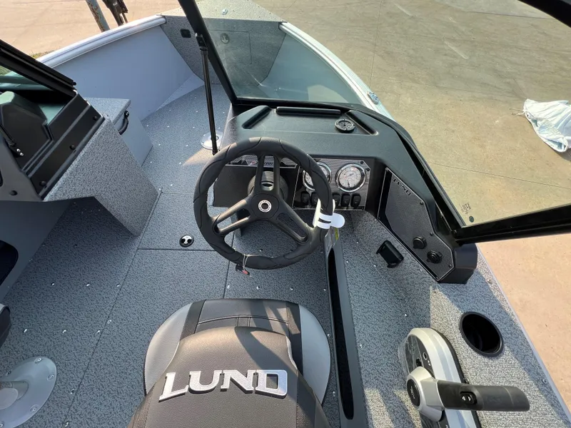 Slide: The Image of 2025 Lund 1875 Alaskan Sport boat interior with steering wheel and dashboard. - 11
