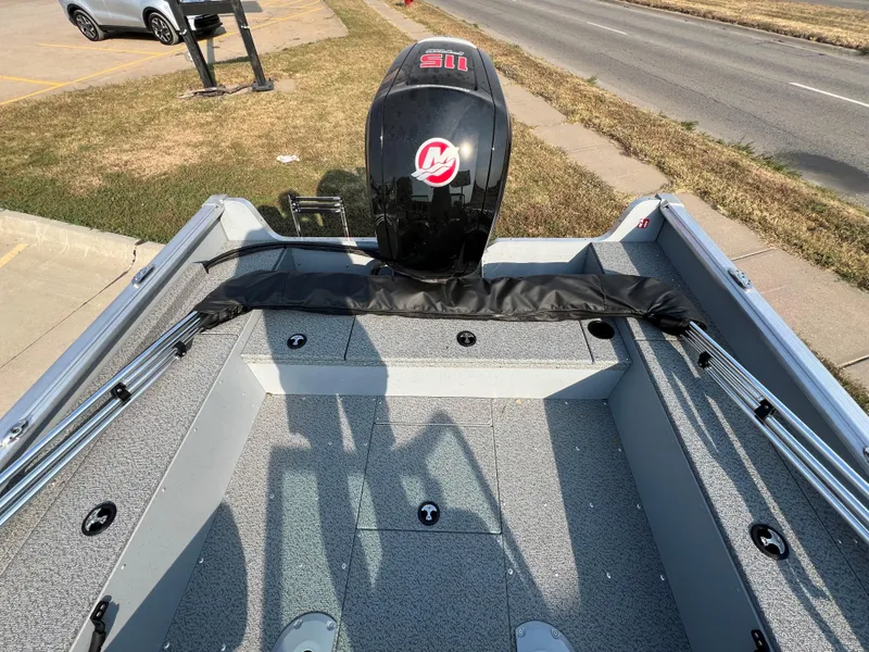 Slide: The Image of 2025 Lund 1875 Alaskan Sport boat with motor, parked near a road. - 6