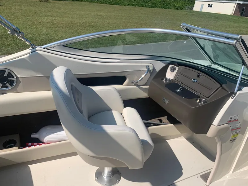 Slide: The Image of 2009 Sea Ray 230 Sundeck interior with helm and seating, showcasing sleek design and functionality. - 11