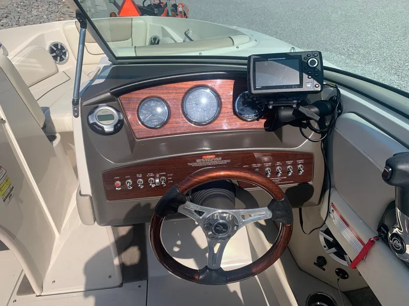 Slide: The Image of 2009 Sea Ray 230 Sundeck dashboard with steering wheel and navigation system. - 12