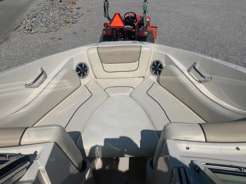 Slide: The Image of 2009 Sea Ray 230 Sundeck interior with beige seating and a tractor in the background. - 15