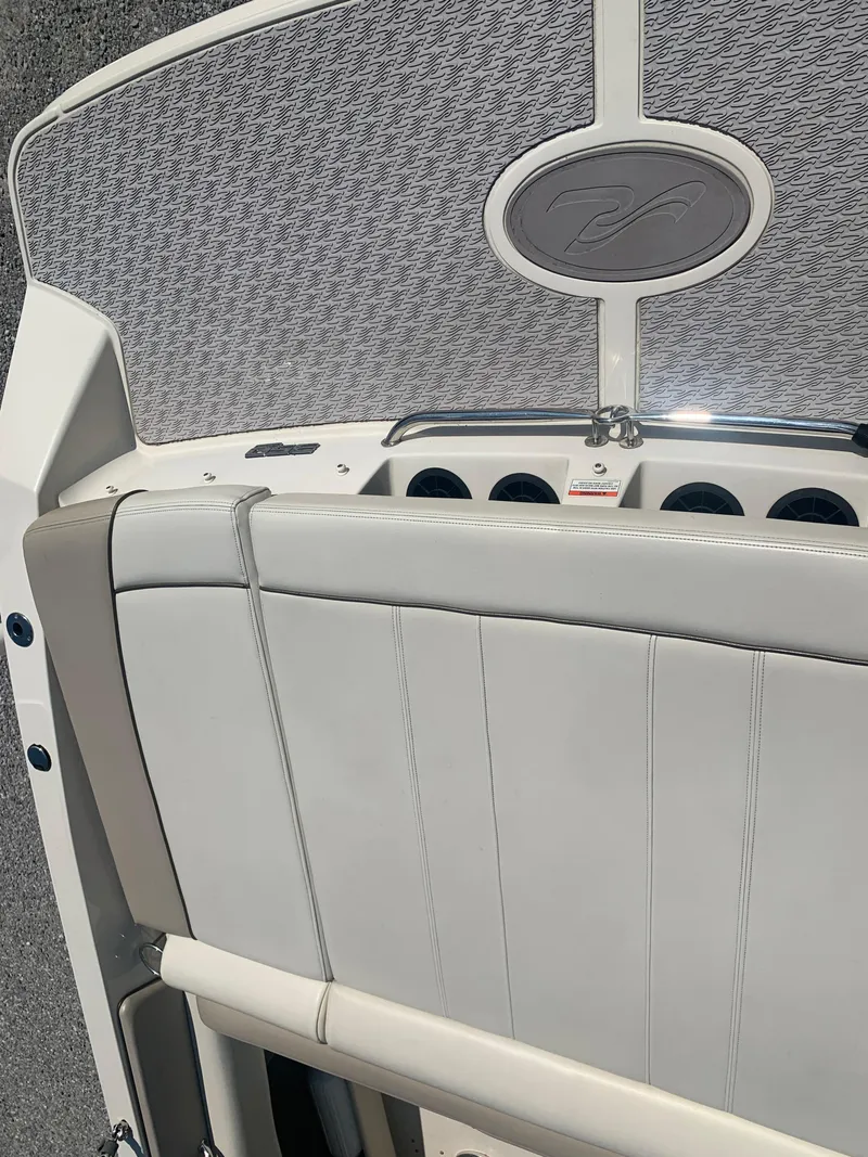 Slide: The Image of 2009 Sea Ray 230 Sundeck boat interior with cushioned seating and dashboard details. - 23