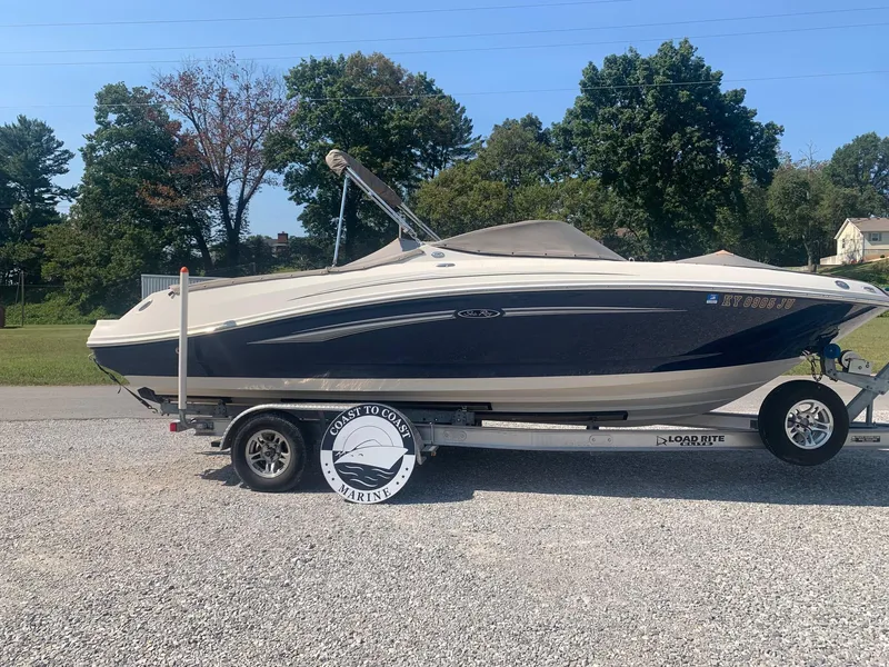 Slide: The Image of 2009 Sea Ray 230 Sundeck boat on trailer, parked outdoors. - 4