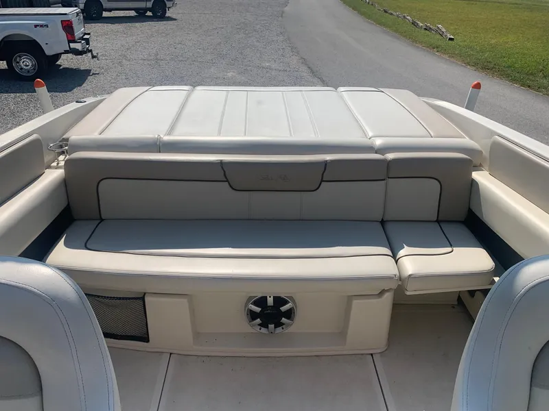 Slide: The Image of 2009 Sea Ray 230 Sundeck boat interior with cushioned seating and speaker. - 9