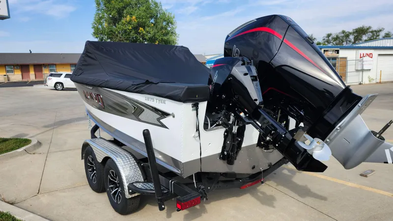 Slide: The Image of 2025 Lund 1875 Tyee boat on trailer with covered motor in parking lot. - 3