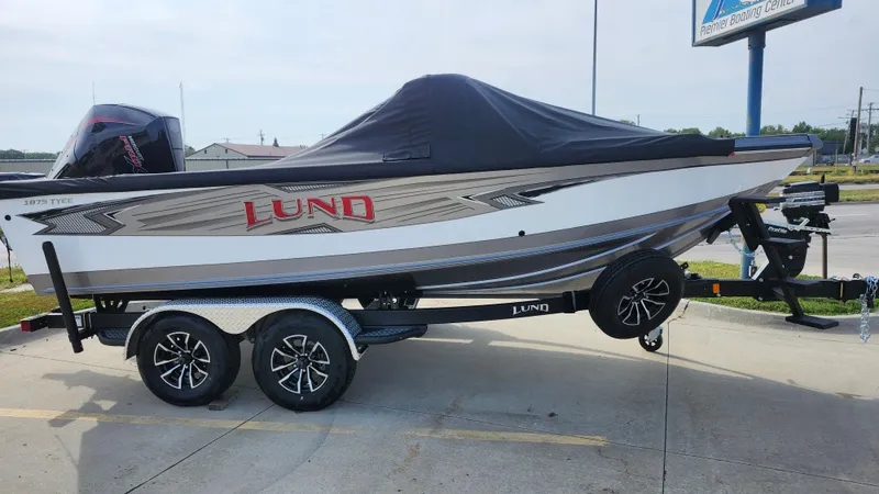 Slide: The Image of 2025 Lund 1875 Tyee boat on trailer, covered and parked outdoors. - 4