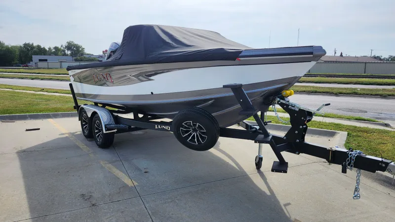 Slide: The Image of 2025 Lund 1875 Tyee boat on trailer, covered and parked outdoors. - 6