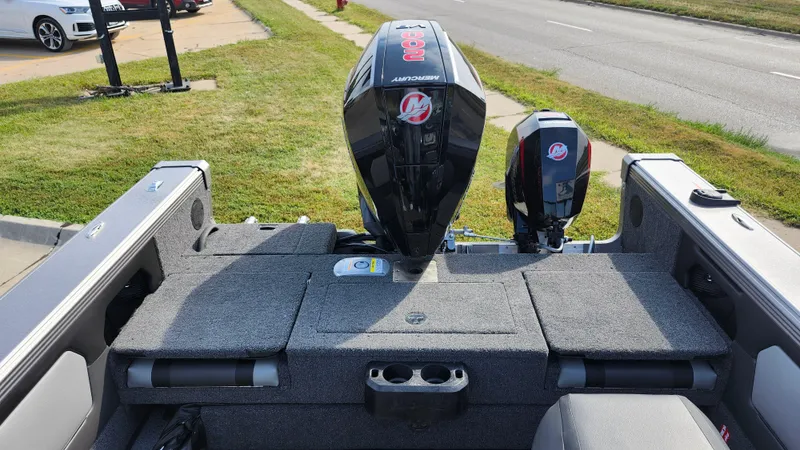 Slide: The Image of 2025 Lund 1875 Tyee boat with Mercury outboard motor, parked on grass. - 8
