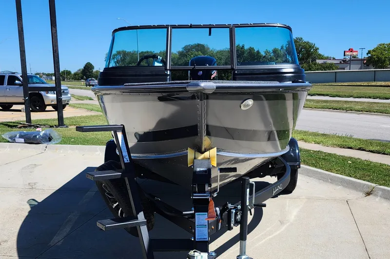 Slide: The Image of 2025 Lund 1775 Impact XS Sport boat on trailer, parked outdoors. - 19