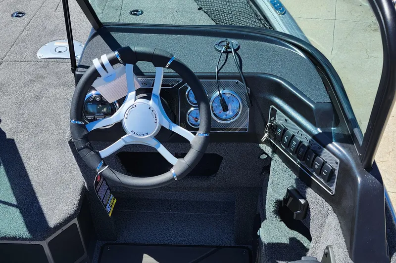 Slide: The Image of 2025 Lund 1775 Impact XS Sport boat steering console with modern controls and gauges. - 21