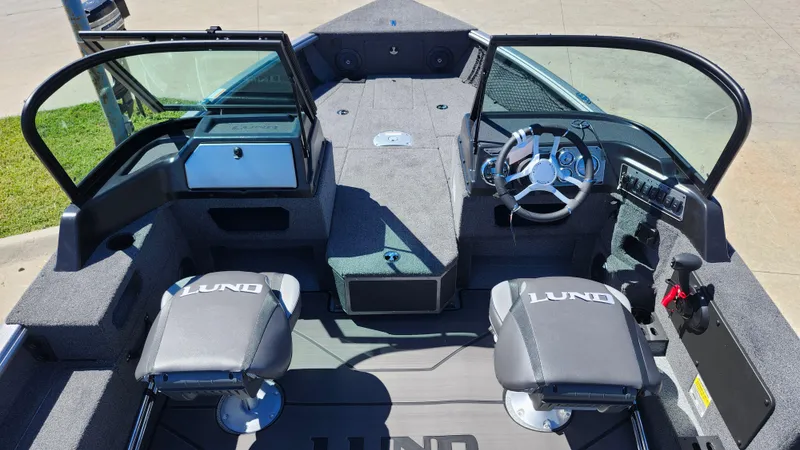 Slide: The Image of 2025 Lund 1775 Impact XS Sport boat interior with dual seats and steering console. - 5