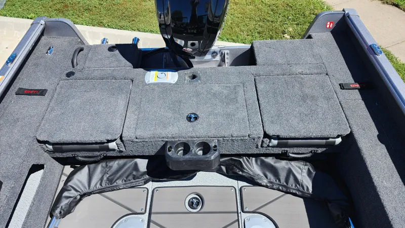 Slide: The Image of 2025 Lund 1775 Impact XS Sport boat interior with storage compartments and motor. - 7