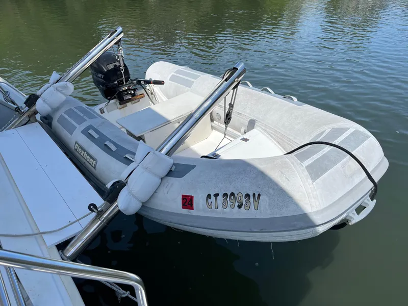 Slide: The Image of Inflatable dinghy attached to a 2007 Lagoon 420 catamaran on calm water. - 11