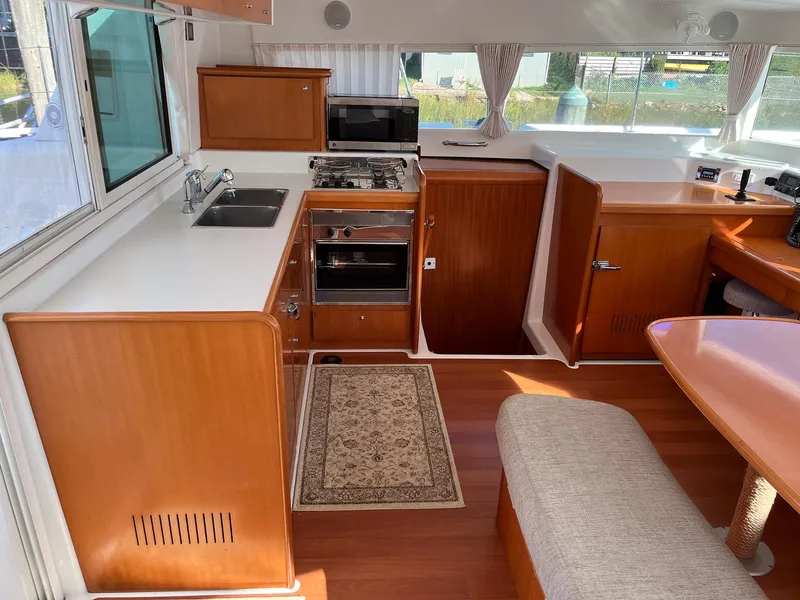 Slide: The Image of Interior of 2007 Lagoon 420 yacht kitchen with wood cabinetry and modern appliances. - 15