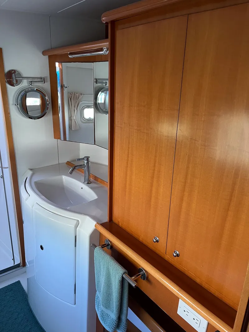 Slide: The Image of 2007 Lagoon 420 yacht bathroom with wooden cabinets and modern sink. - 32