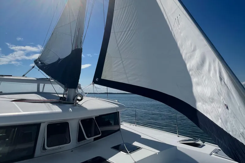 Slide: The Image of Lagoon 420 catamaran sailing on open water under clear blue skies. - 43