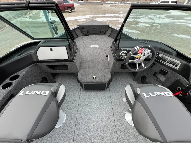 Slide: The Image of 2025 Lund 1875 Impact XS Sport boat interior with dual seats and steering console. - 16