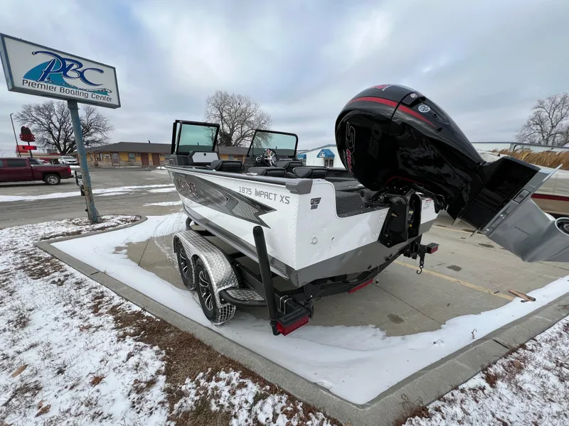 Slide: The Image of 2025 Lund 1875 Impact XS Sport boat on trailer in snowy parking lot. - 4