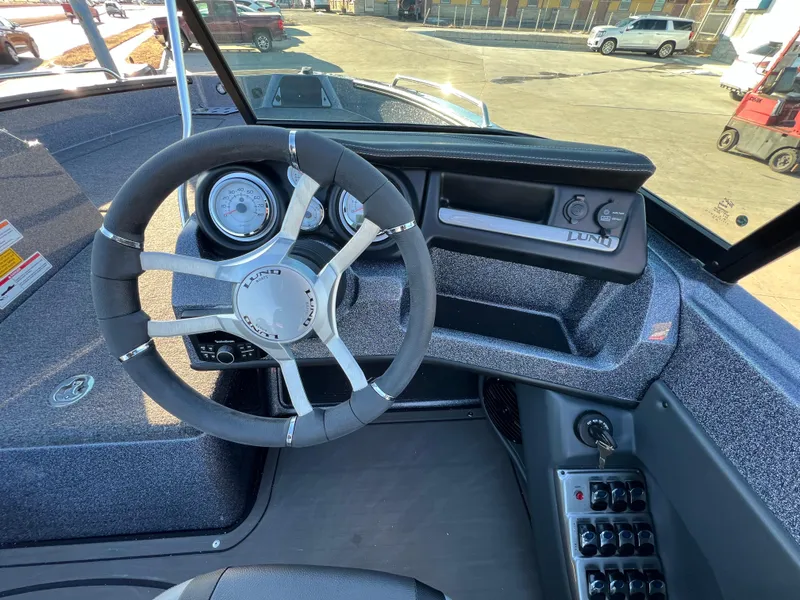 Slide: The Image of 2025 Lund 189 Pro-V GL boat dashboard with steering wheel and control panel. - 15