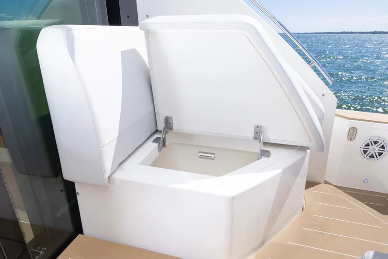 Slide: The Image of Tiara Yachts EX 54 2025, open storage compartment on deck, ocean view. - 11