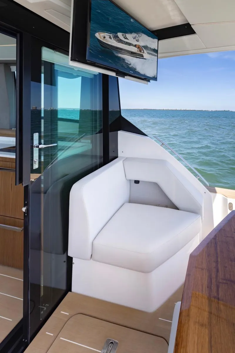 Slide: The Image of 2025 Tiara Yachts EX 54 interior with white seating and ocean view. - 23