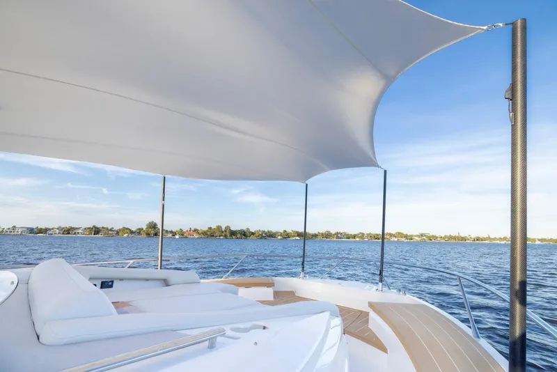 Slide: The Image of Luxurious 2025 Tiara Yachts EX 54 deck with canopy, overlooking serene waters. - 25