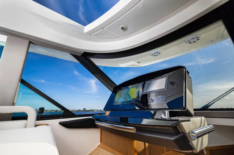 Slide: The Image of Interior of 2025 Tiara Yachts EX 54, featuring modern navigation system and panoramic windows. - 34