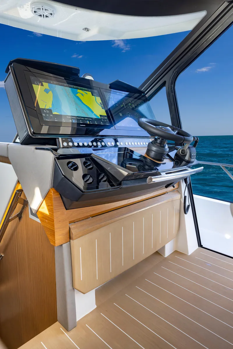 Slide: The Image of 2025 Tiara Yachts EX 54 helm with advanced navigation system on open sea. - 35