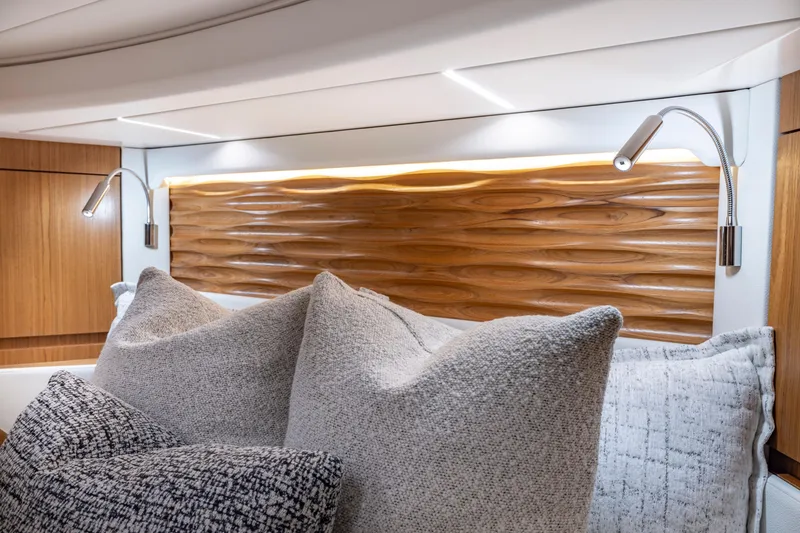 Slide: The Image of Luxurious 2025 Tiara Yachts EX 54 cabin with elegant wood paneling and plush pillows. - 44