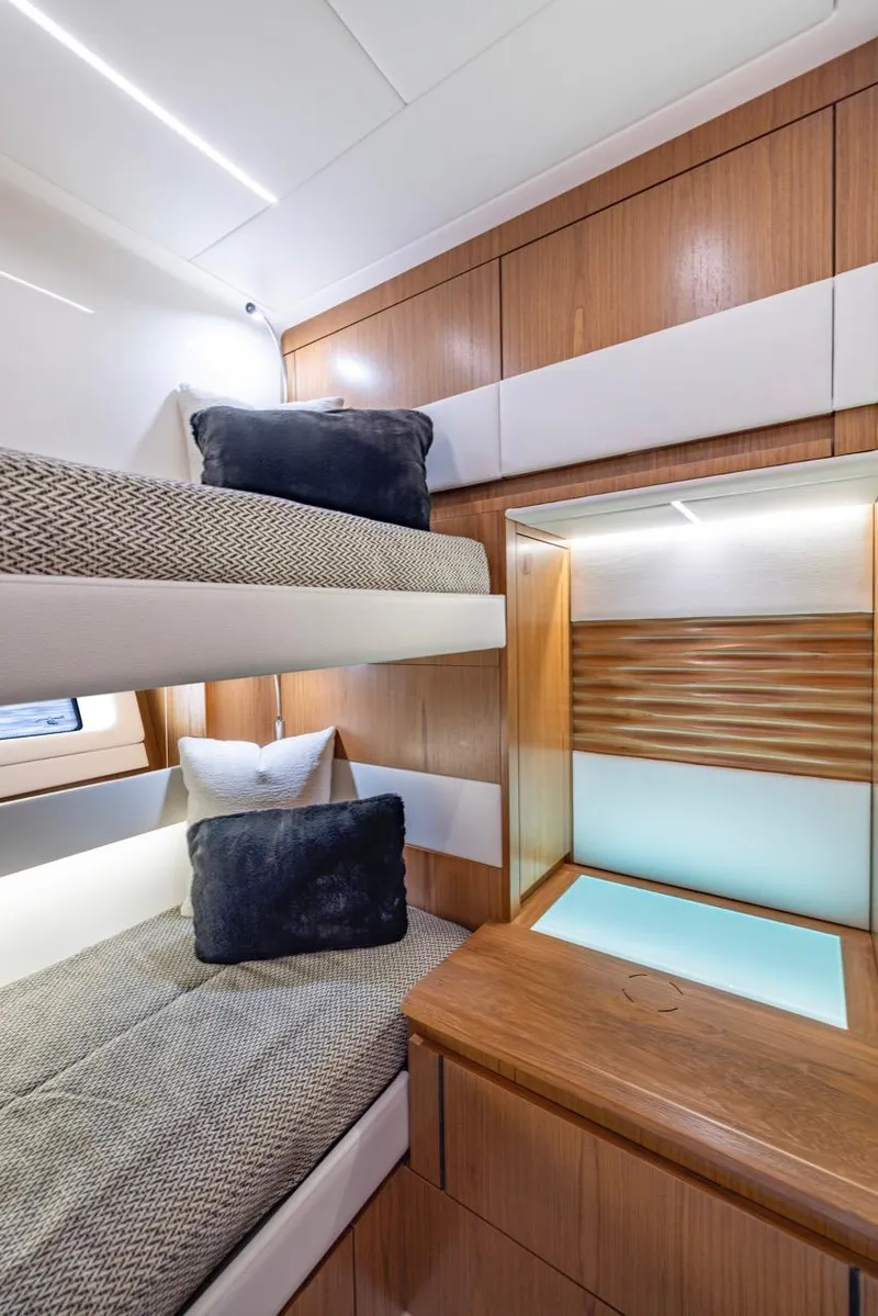 Slide: The Image of Interior of 2025 Tiara Yachts EX 54 with modern bunk beds and wooden cabinetry. - 47