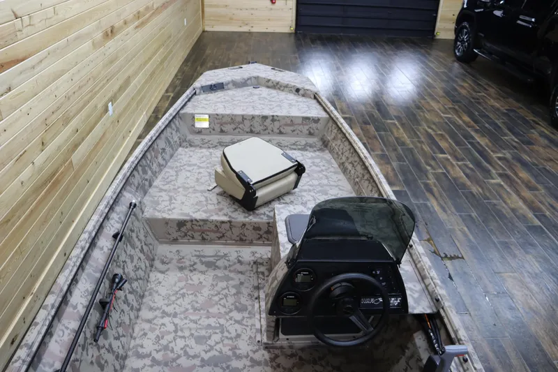 Slide: The Image of 2025 War Eagle 648LDSV boat with camouflage interior in a wooden garage. - 12
