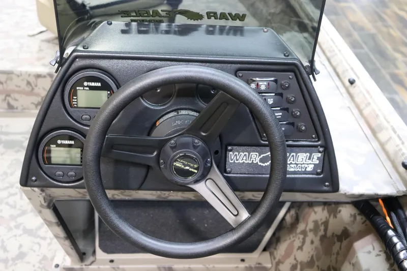 Slide: The Image of 2025 War Eagle 648LDSV boat dashboard with steering wheel and Yamaha gauges. - 13