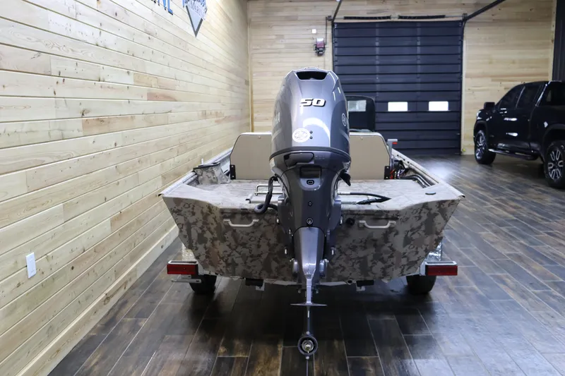 Slide: The Image of 2025 War Eagle 648LDSV boat with 50HP motor in a wooden garage. - 3