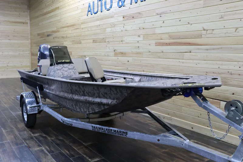 Slide: The Image of 2025 War Eagle 648LDSV boat on trailer in showroom with wood panel walls. - 6