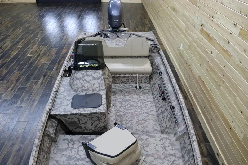 Slide: The Image of 2025 War Eagle 648LDSV boat with camouflage interior in a wooden showroom. - 9
