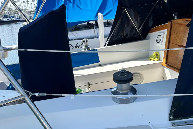 Slide: The Image of 1988 Catalina mrk.1 sailboat deck with winch and blue covers in marina setting. - 2