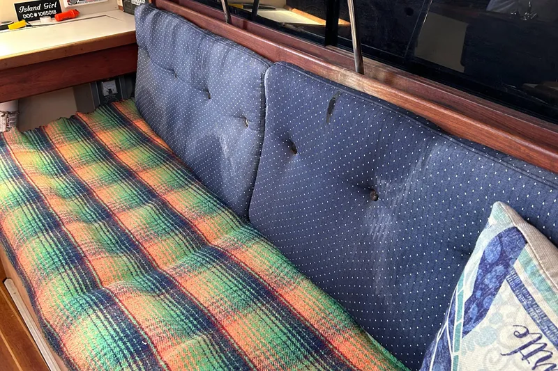 Slide: The Image of 1988 Catalina mrk.1 interior with blue cushions and colorful plaid blanket. - 4
