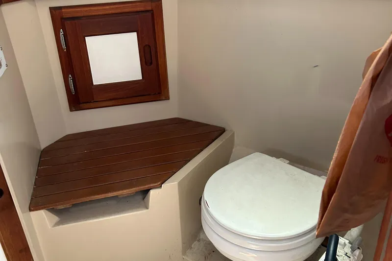 Slide: The Image of 1988 Catalina mrk.1 boat bathroom with wooden seat and small window. - 5