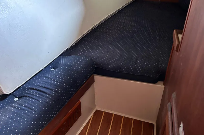 Slide: The Image of 1988 Catalina mrk.1 cabin interior with blue cushions and wooden flooring. - 9