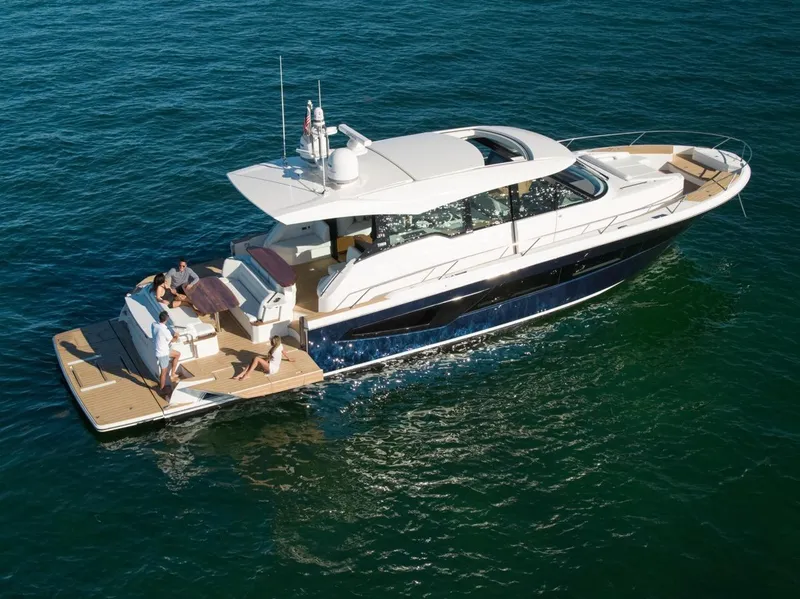 Slide: The Image of 2025 Tiara Yachts EX 60 cruising on open water, featuring sleek design and spacious deck. - 2