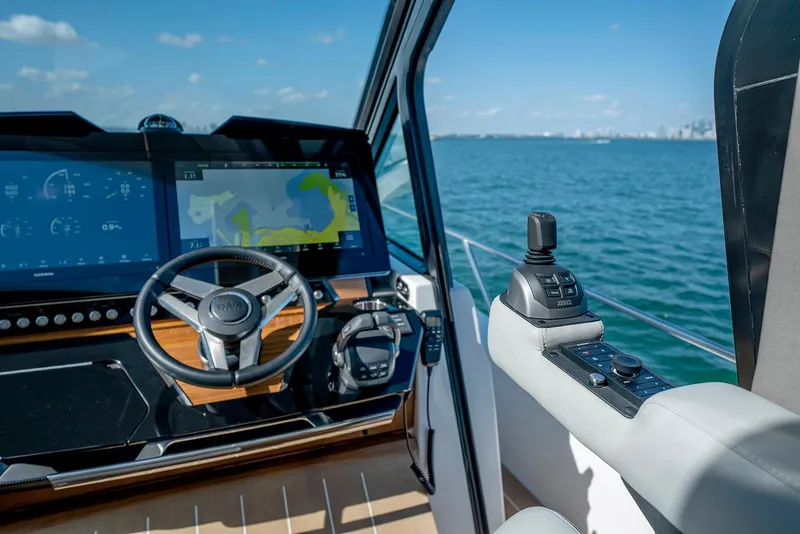 Slide: The Image of 2025 Tiara Yachts EX 60 helm with advanced navigation system on open water. - 33