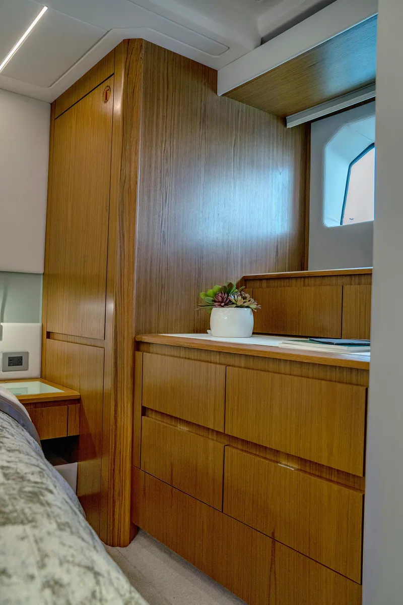 Slide: The Image of 2025 Tiara Yachts EX 60 interior with wooden cabinetry and porthole window. - 35