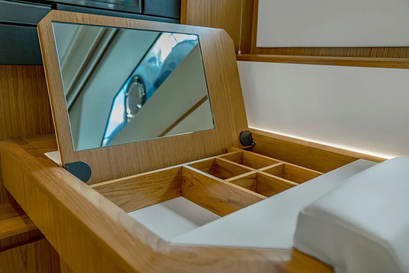 Slide: The Image of Luxury vanity area on 2025 Tiara Yachts EX 60 with mirror and storage compartments. - 39