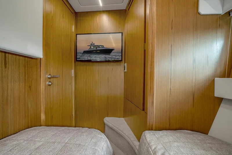 Slide: The Image of Interior cabin of 2025 Tiara Yachts EX 60 with wood paneling and twin beds. - 43